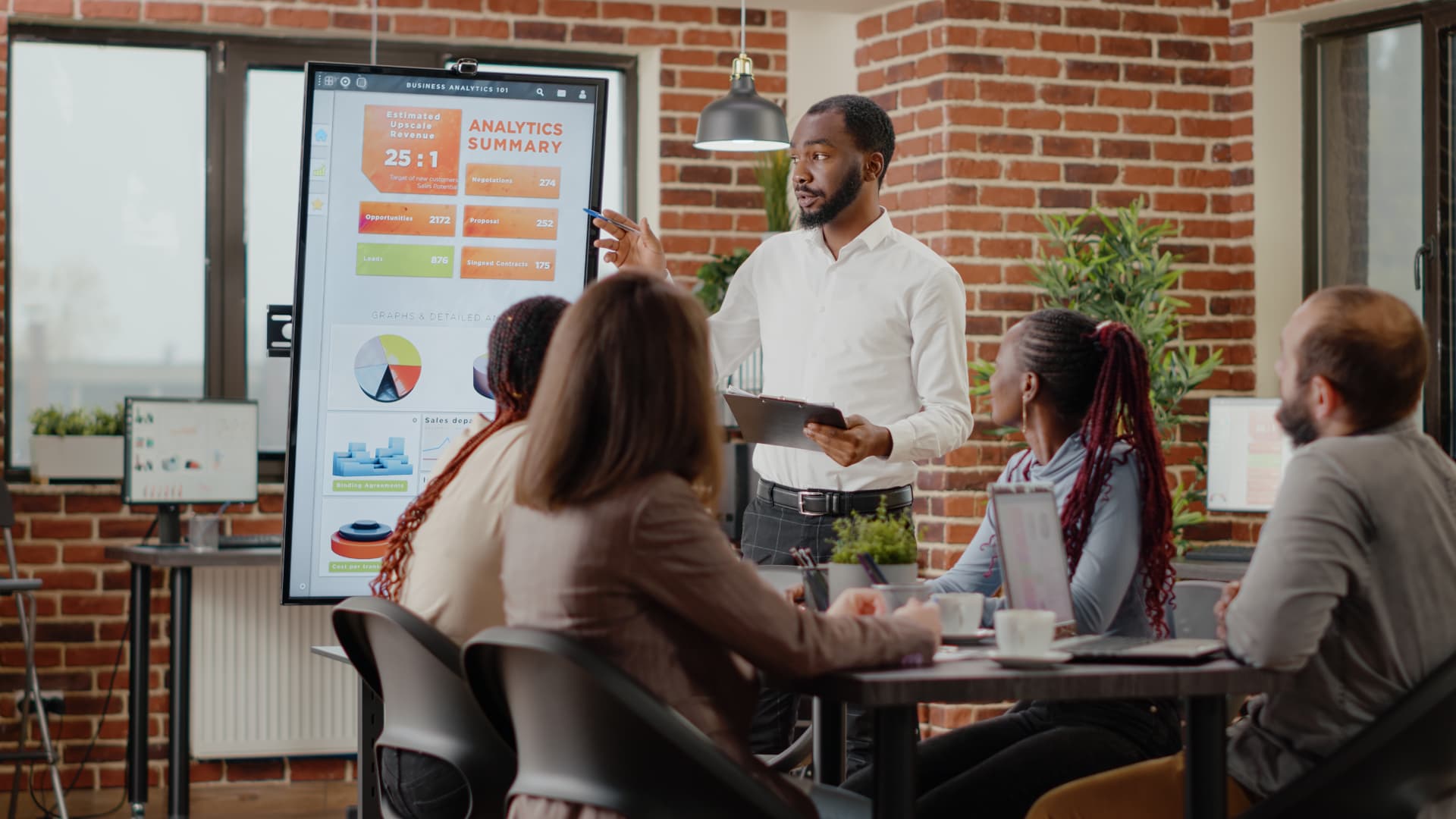A facilitator presenting business analytics and financial charts to a team in a training session